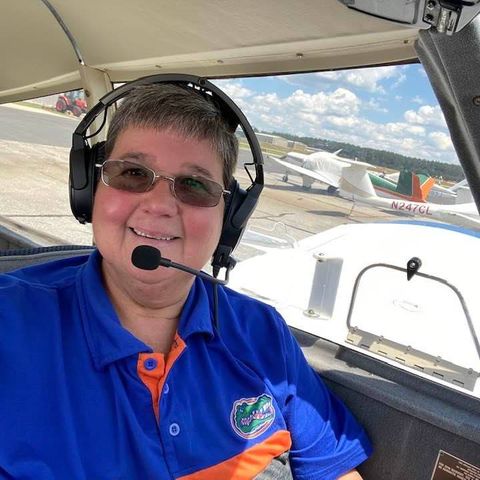 Sue Blanchard sitting in the pilot's seat of a Piper airplane.